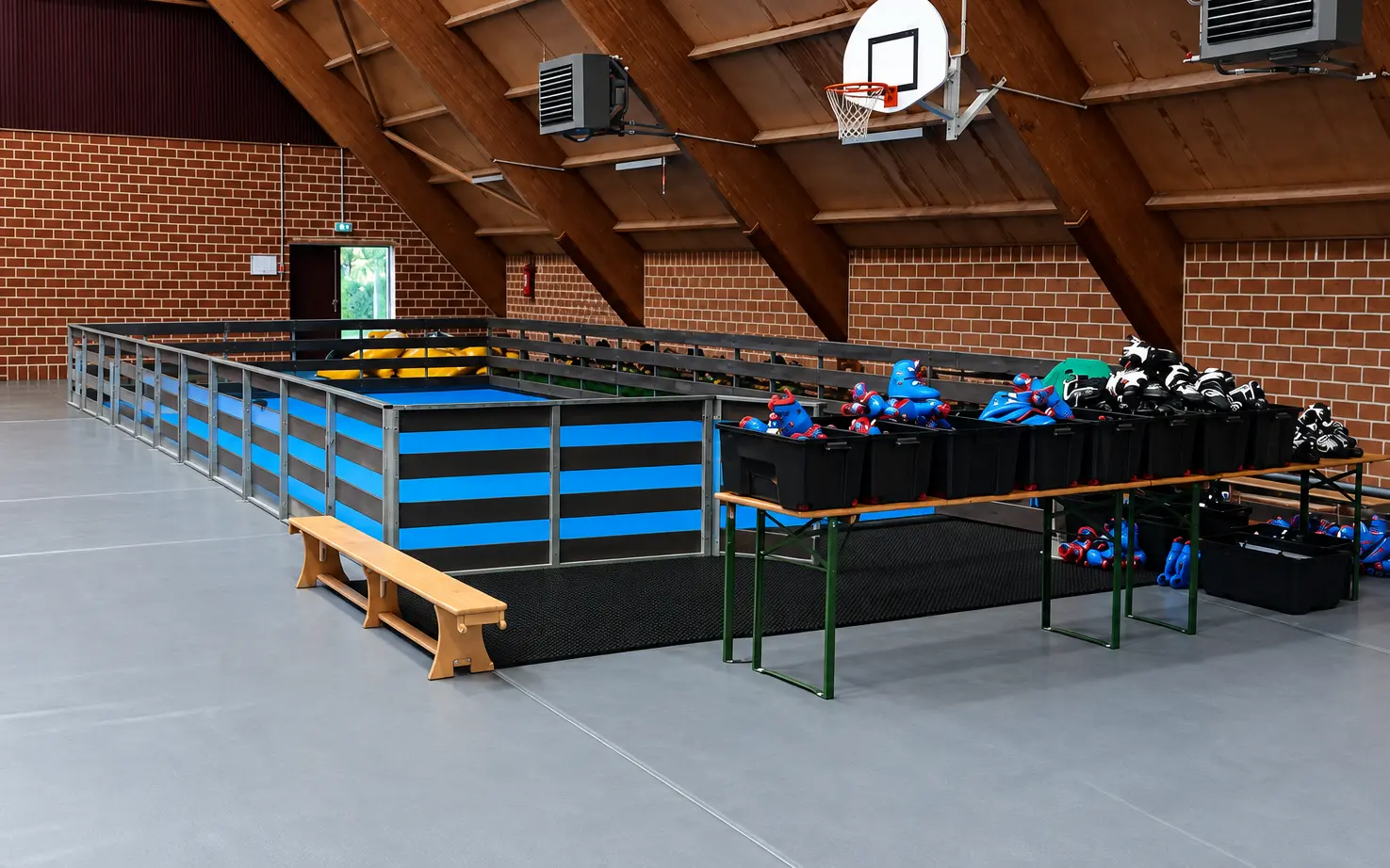 Une piste de roller et ses bacs de patins dans une salle de sport